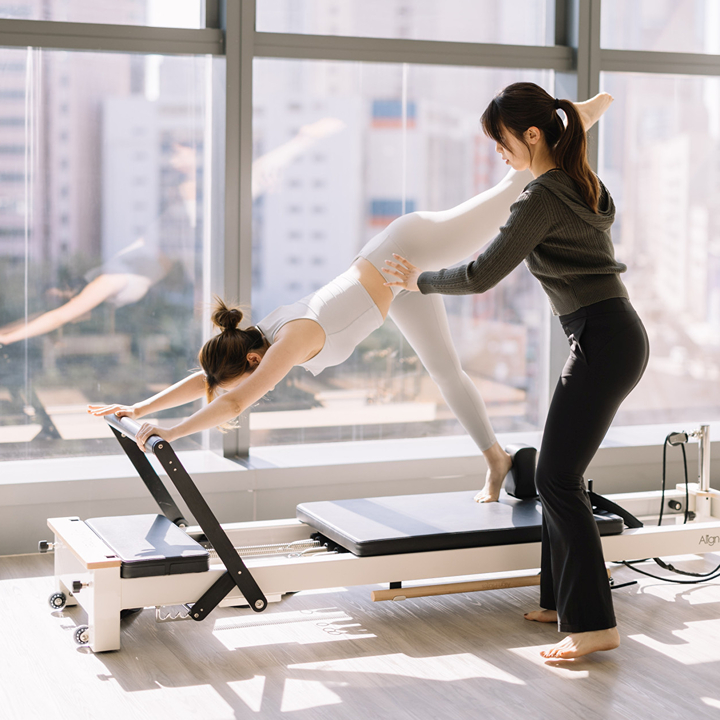 pilates coach and student working in a reformer focused session at donuts pilates studio in hong kong
