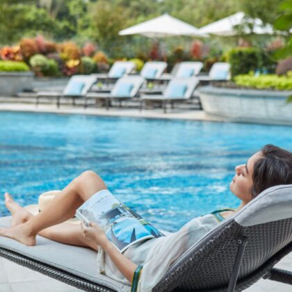 the best hotel day pass in hong kong woman laying on a pool bench by the swimming pool